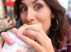 AUTOIMMUNE ISSUES: WOMAN EATING A SANDWICH