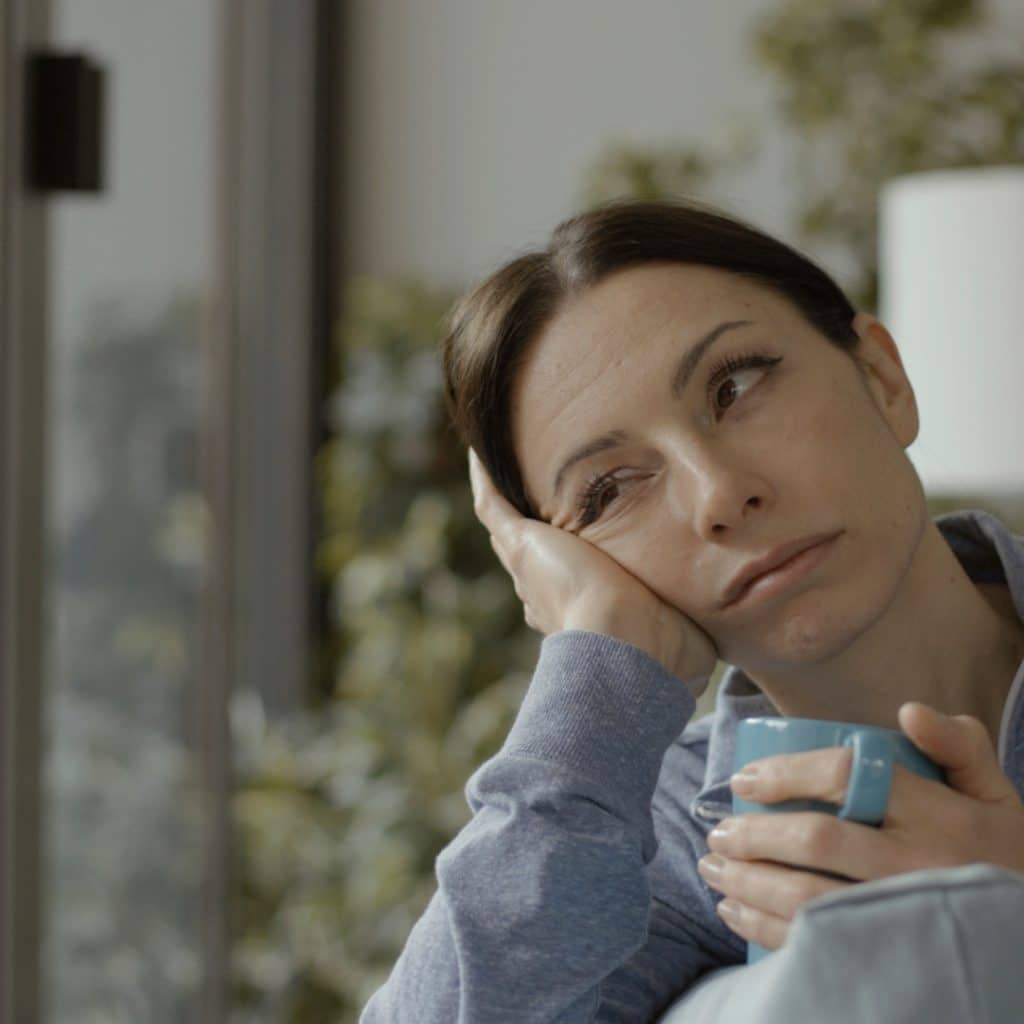 better caffeine choices: sad woman holding a cup of coffee