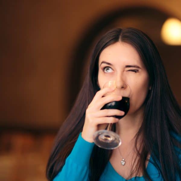 WOMAN DRINKING GLASS OF RED WINE