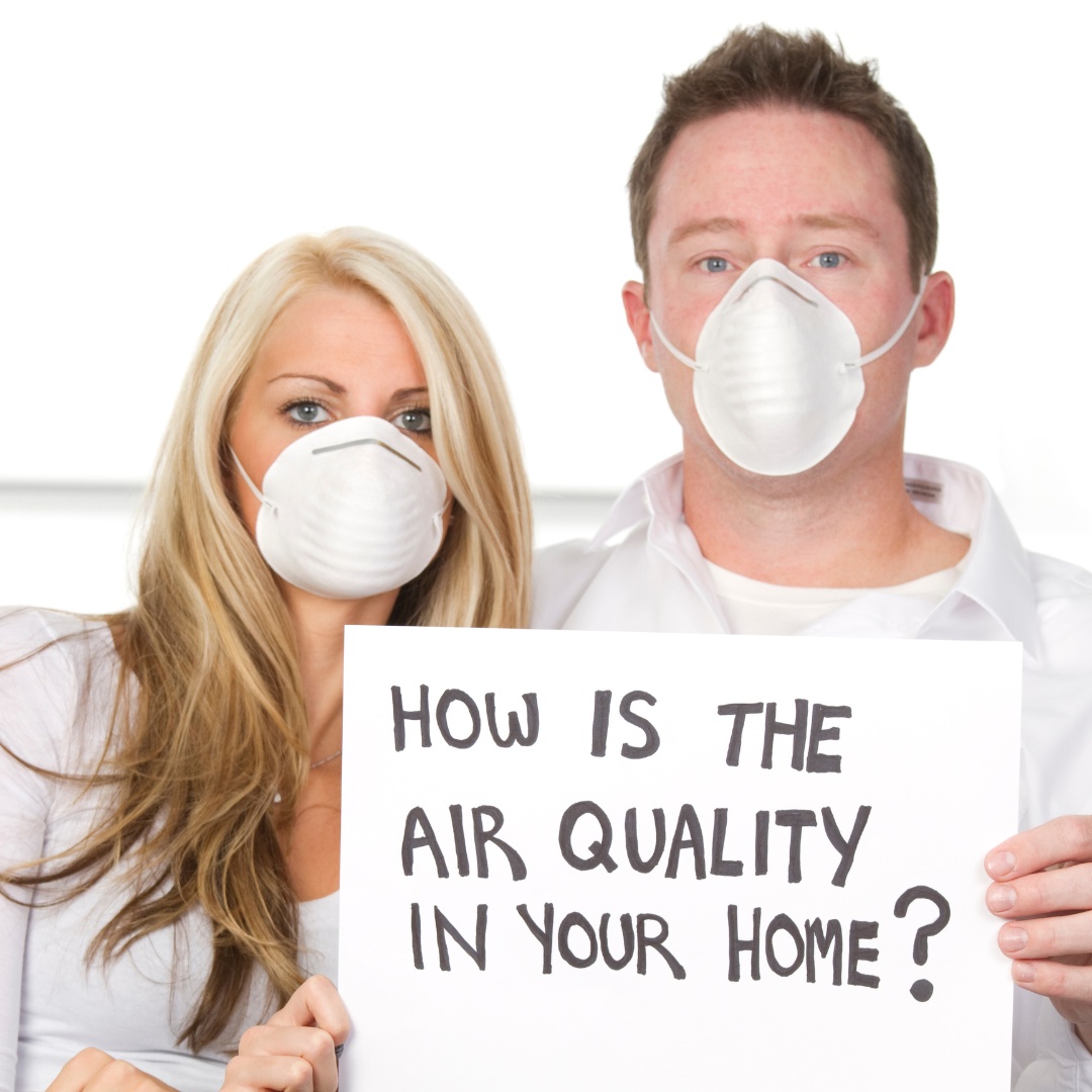 man-and-woman-wearing-masks-holding-sign-saying-how-is-the-air-quality-in-your-home