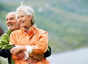 HEALTHSPAN VS LIFESPAN: MAN AND WOMAN EMBRACING IN FRONT OF A LAKE